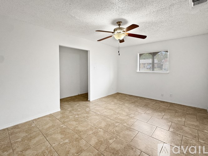 A room with a ceiling fan and a window with blinds.
