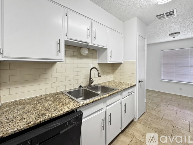 A kitchen with granite countertops and white cabinets.