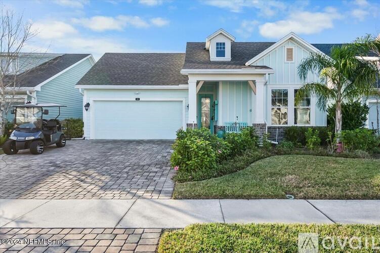 A house with a white garage door and a brick driveway.