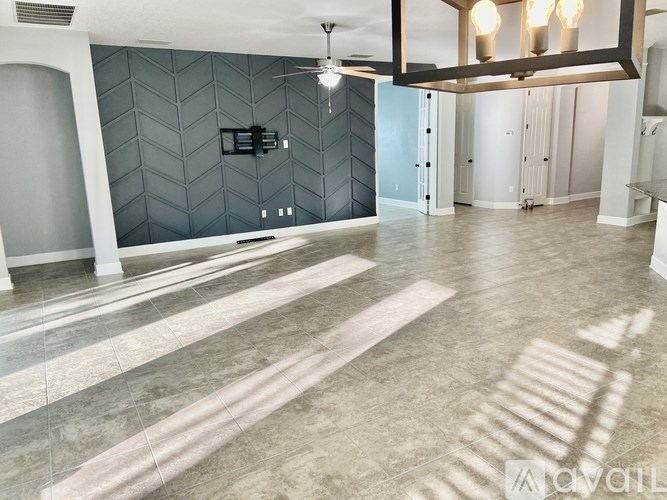 A spacious room with a tiled floor and a ceiling fan.