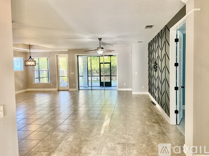 A spacious room with a ceiling fan and sliding glass doors.