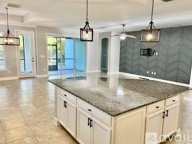 A kitchen with a granite countertop and white cabinets.