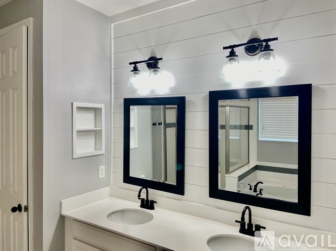 A bathroom with a white countertop and a mirror above the sink.