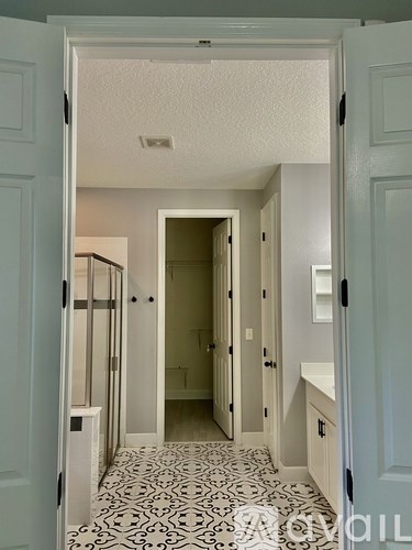 A hallway with a black and white floor and white walls.