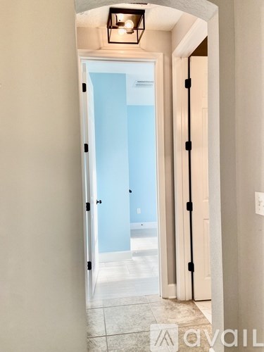 A hallway with a door leading to a balcony.