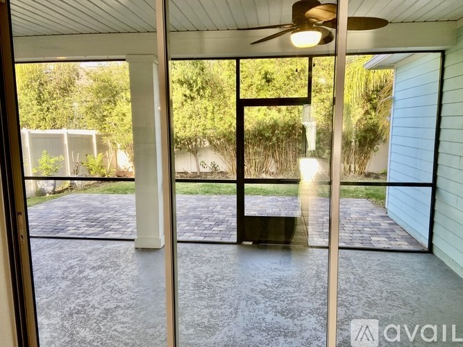 A patio with a ceiling fan and sliding glass doors.
