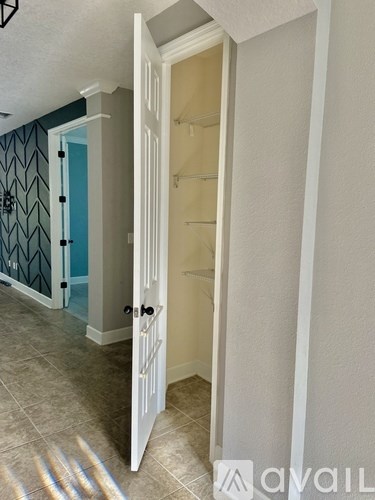 A white door is open to a room with a blue door.