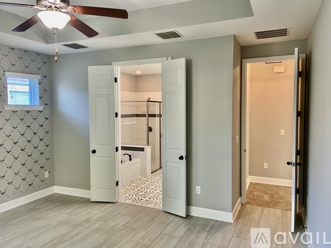 A room with a ceiling fan and a patterned wallpaper.