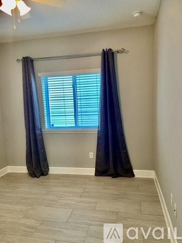 A room with a window covered by blue curtains.