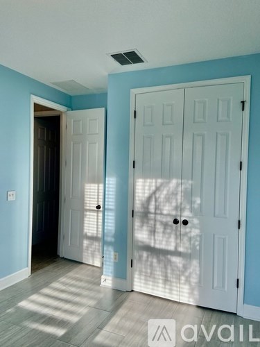 A room with a white door and a blue wall.