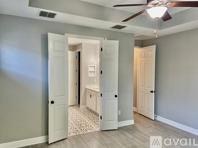 A room with a ceiling fan and a rug on the floor.