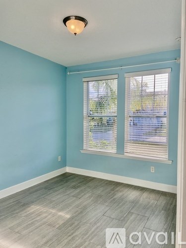 A room with a window and a view of a parking lot.