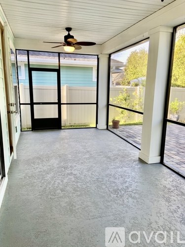 A room with a ceiling fan and sliding glass doors.
