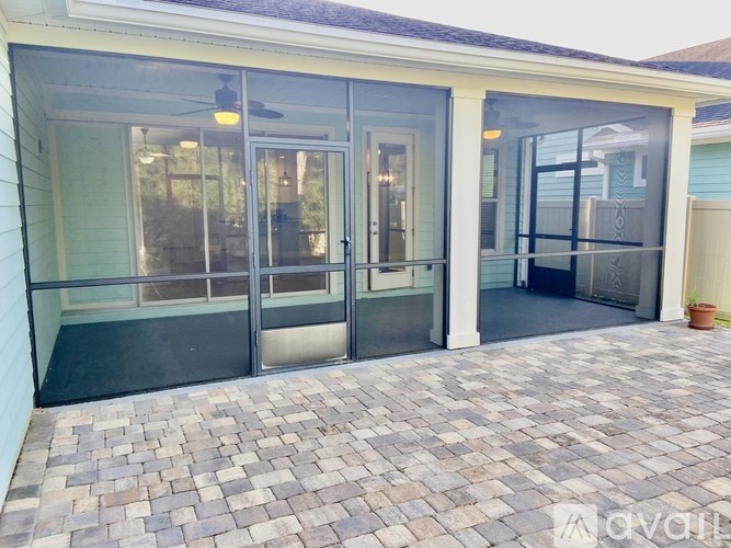 A patio with a glass door and a fan.