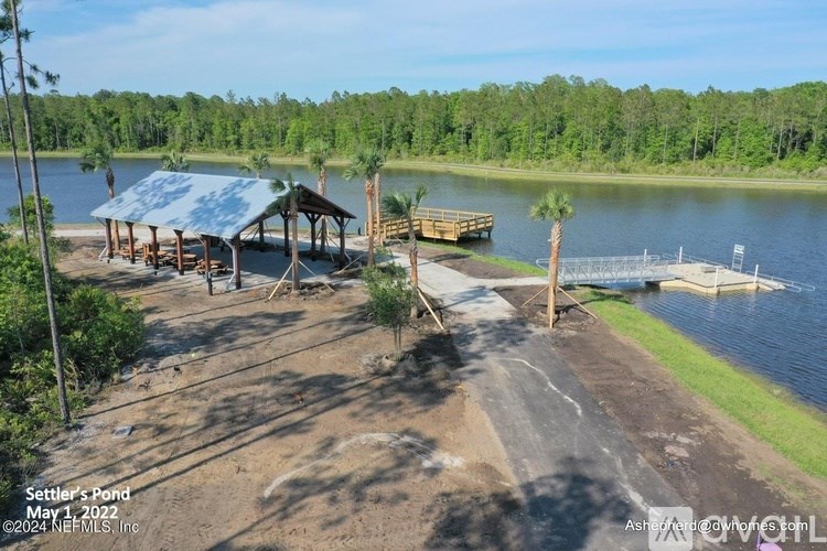 A pond with a dock and a pavilion.