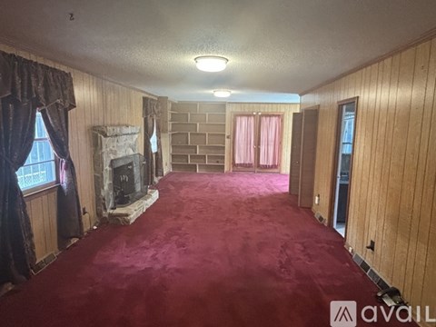 A room with a red carpet and wooden walls.