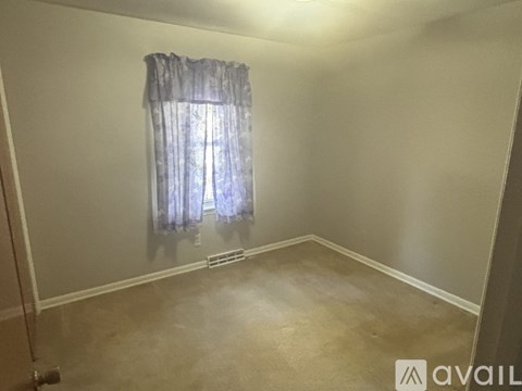 A room with a window and a curtain.