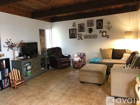 A living room with a brown leather chair and a brown ottoman.