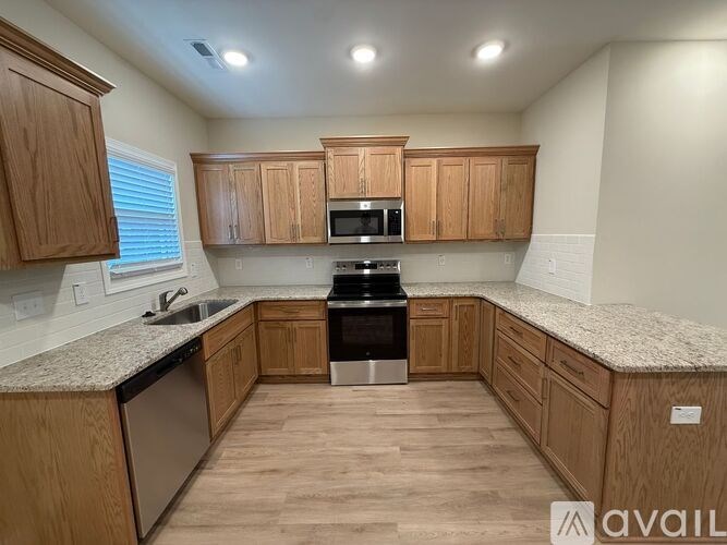A kitchen with wooden cabinets and a granite countertop.