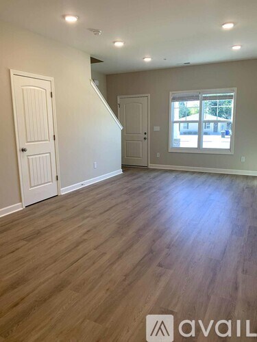 A room with wooden flooring and white walls.