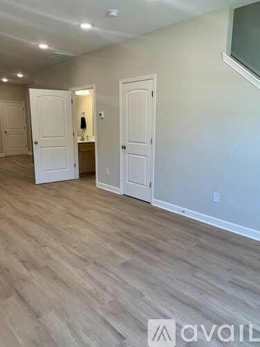 A room with wooden flooring and two white doors.