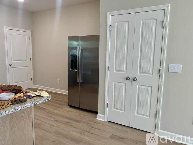 A kitchen with a refrigerator, a counter, and a door.