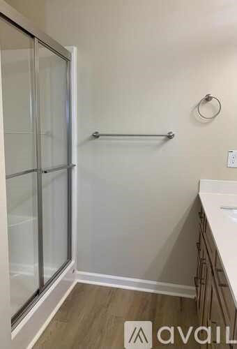 A bathroom with a glass shower door and a towel bar.