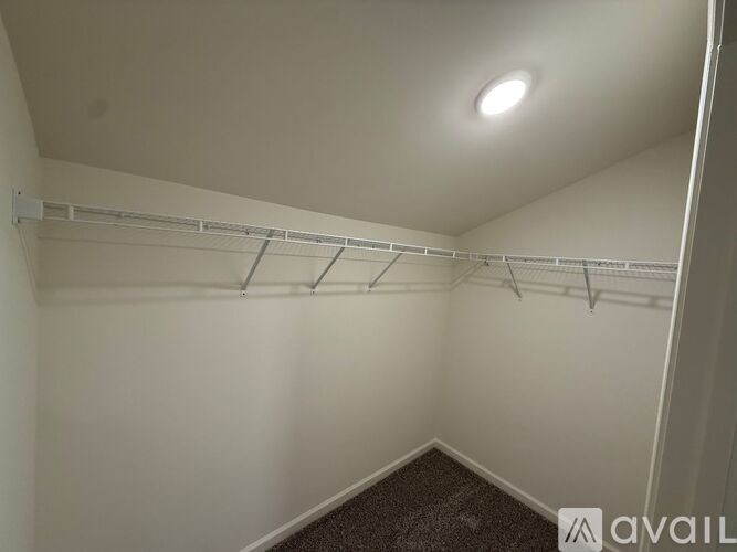 A white wall with a row of silver hooks on it.