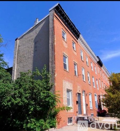 A red brick building with a black roof and white trim.