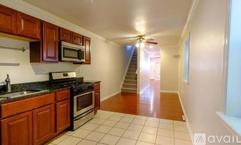 A kitchen with wooden cabinets and a black stove top oven.