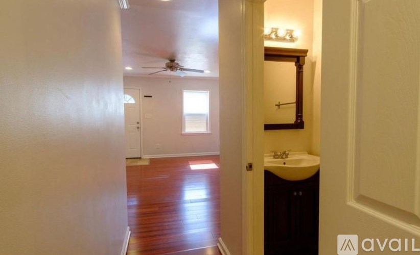 A bathroom with a sink and mirror is visible from the doorway.