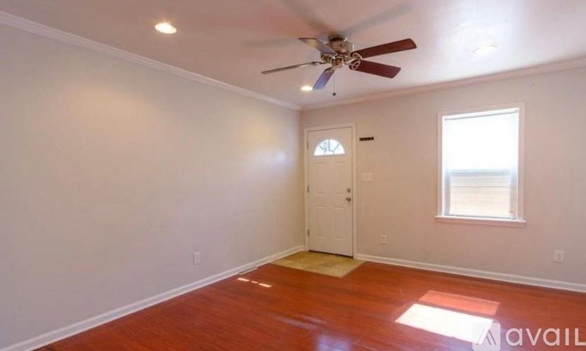A room with a ceiling fan and a door leading to a balcony.