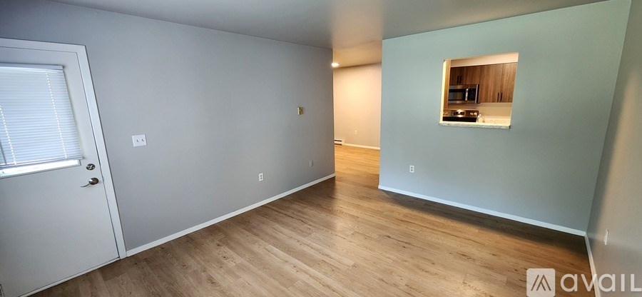 A room with a door and a window with a view of a balcony.