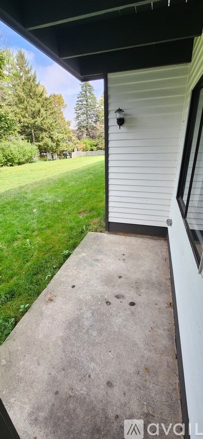 A white house with a black roof and a small porch.