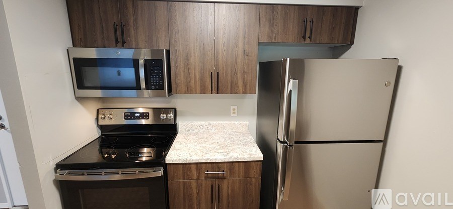 A kitchen with a stove, microwave, and refrigerator.