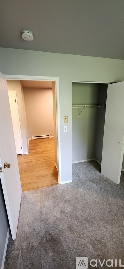 A room with a carpeted floor and a doorway leading to another room.