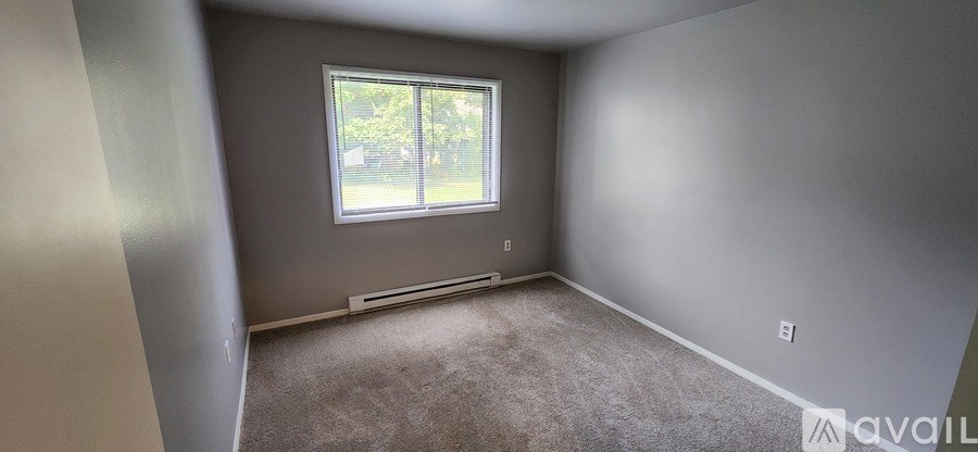 A room with a window and carpeted floor.