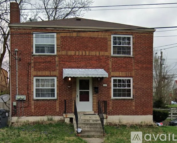 A red brick house with a white door and windows.