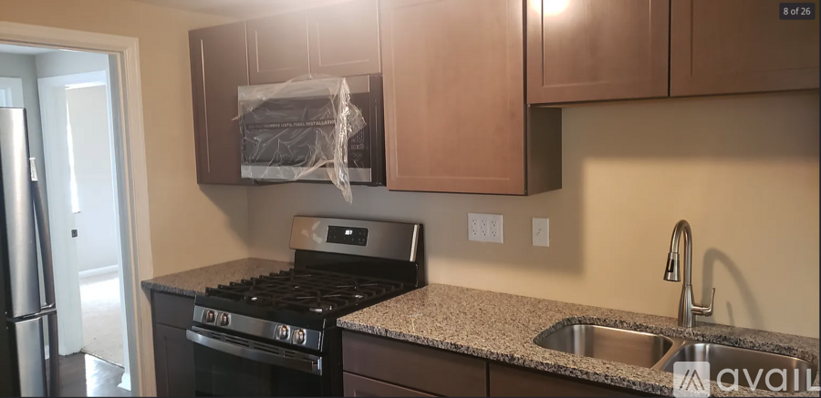 A kitchen with a black stove top oven and a granite counter top.