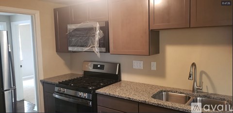 A kitchen with a black stove top oven and a granite counter top.