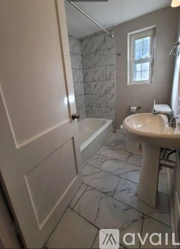 A bathroom with a marble tile floor and a white sink.