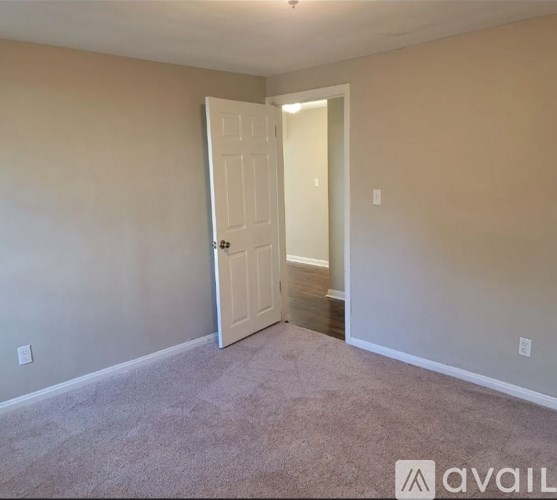 A room with a white door and carpeted floor.
