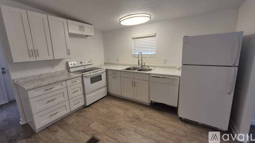 A kitchen with white appliances and cabinets.