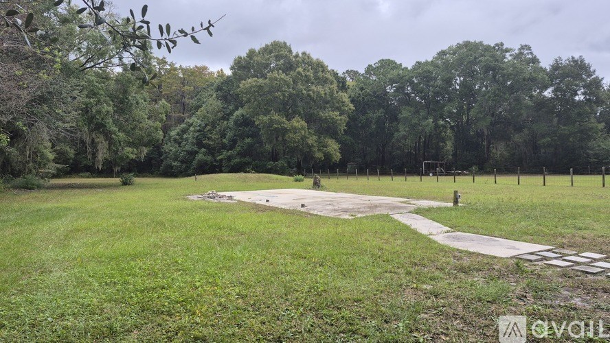 A grassy field with a path and trees in the background.