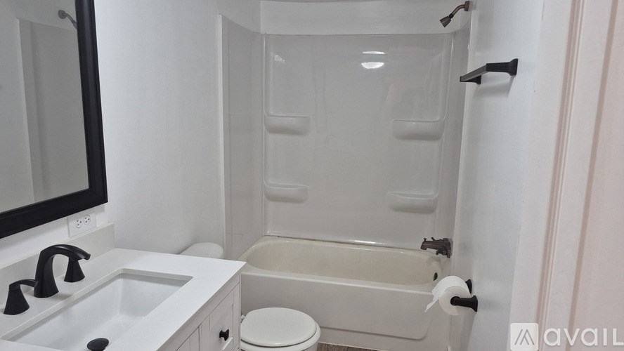 A white bathroom with a toilet, sink, and bathtub.