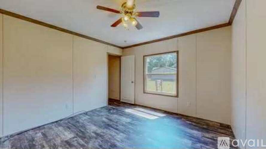 A room with a ceiling fan and a window.