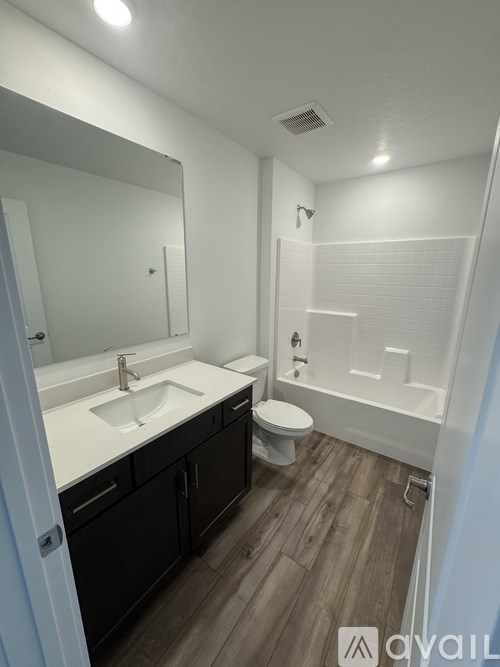 A bathroom with a sink, toilet, and bathtub.