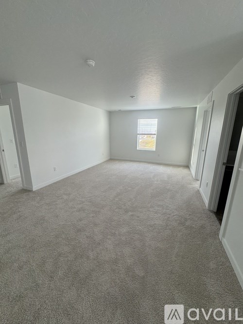A carpeted room with a window and a sign on the wall.