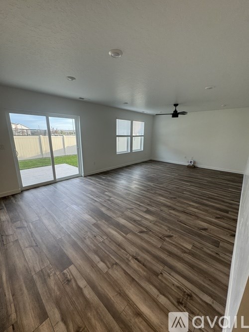A room with wooden flooring and a ceiling fan.