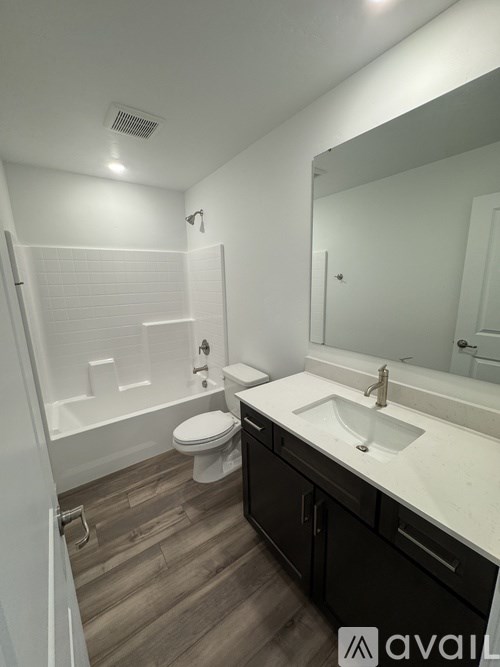 A bathroom with a toilet, sink, and mirror.